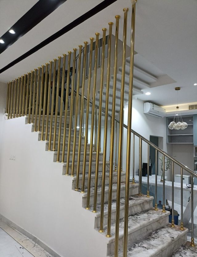 درابزين بقضبان ذهبية رفيعة لدرج حديث
