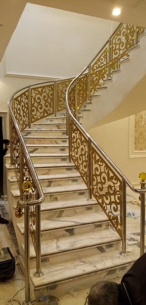 درابزين ذهبي مزخرف بقص ليزر على درج منحنٍ