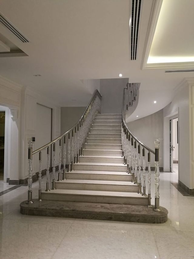 درابزين ستانلس ستيل على درج منحنٍ كبير في بهو